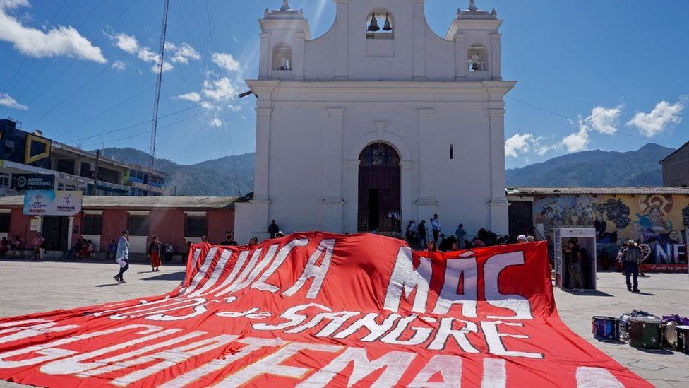 A cloth reading "Rivers of Blood in Guatemala, Never Again" in front of a church during the National Day for the Dignity of the Victims of the Internal Armed Conflict in Guatemala, February 2023.