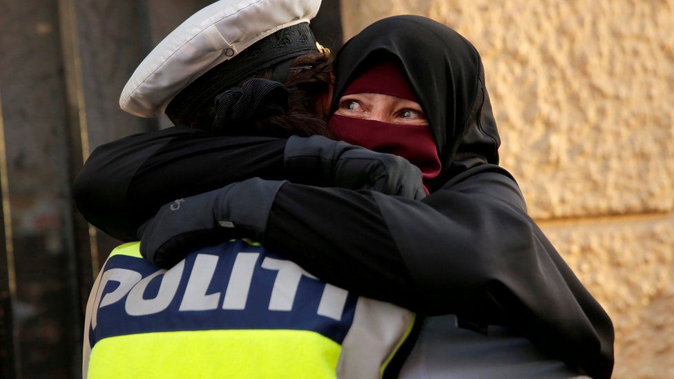 Danish police officer hugs a woman wearing a niqab