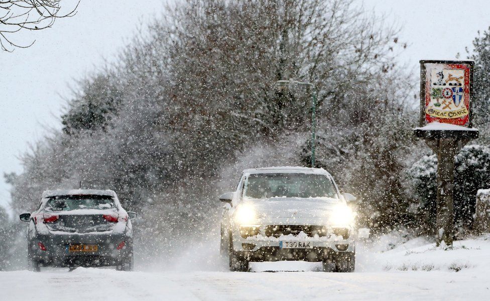 Cars travel through Great Chart in Ashford, Kent, following heavy overnight snowfall