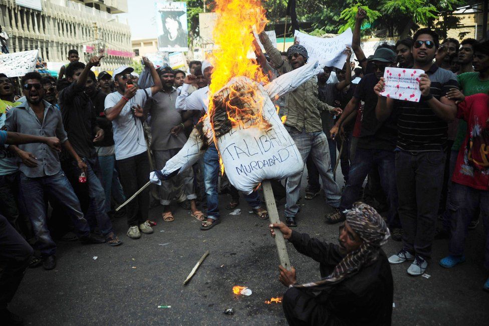 Pakistani Christian burn an effigy of the Taliban during a protest in Karachi on 23 September 2013, in reaction to bomb attacks at a church in Peshawar.