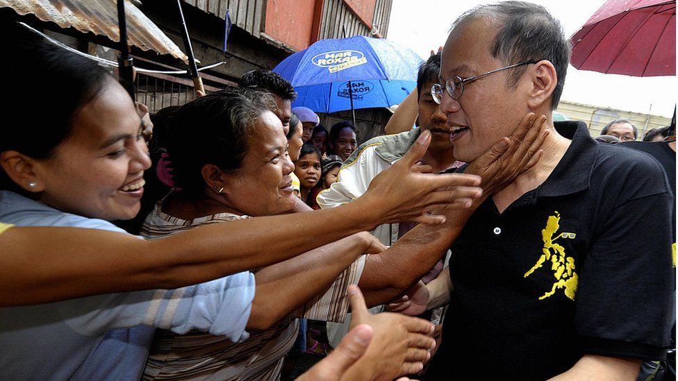 Сенатора Бениньо Акино (справа), известного как «Нойной», сына покойной иконы филиппинской демократии Корасона Акино, 12 сентября 2009 года приветствуют жители бедного района Басеко в Маниле.