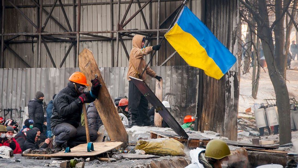 Протестувальники зі щитами і прапорами на барикадах