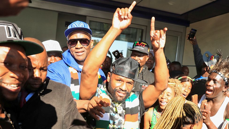 Former US boxing champion Floyd Mayweather gestures to fans upon his arrival at Robert Gabriel Mugabe International Airport in Harare, Zimbabwe - 13 July 2023