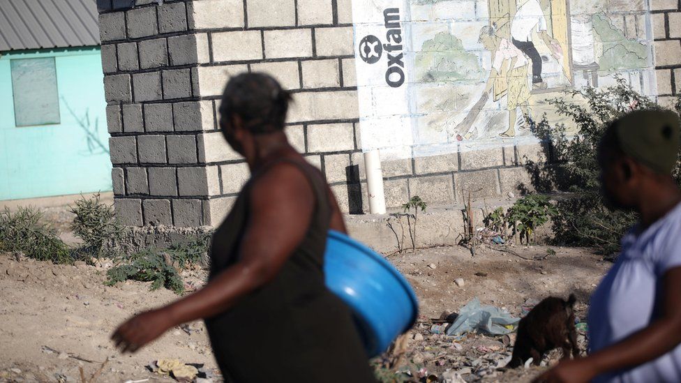 Women walking past Oxfam mural in Haiti in 2018