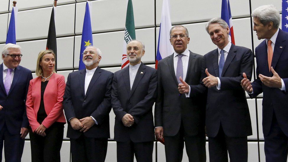 World diplomats stand and smile after signing the Iran nuclear deal in 2015