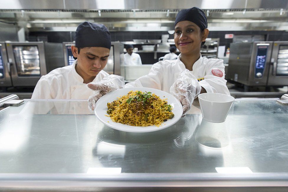 Сотрудник подает тарелку риса бирьяни в ресторане в магазине ИКЕА в Хайтек-Сити на окраине Хайдарабада. Индия, четверг, 9 августа 2018 г.