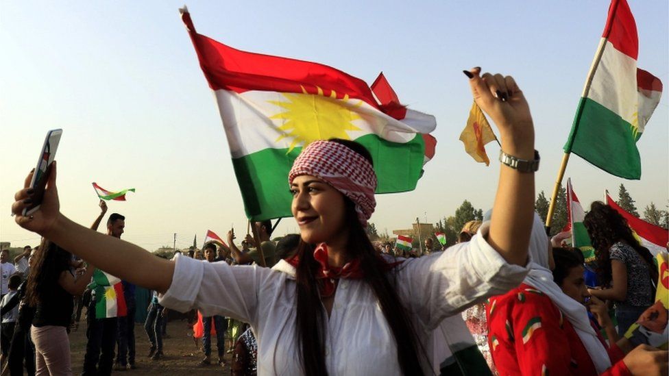 A woman poses for a selfie at a gathering in support of Kurdish independence in September