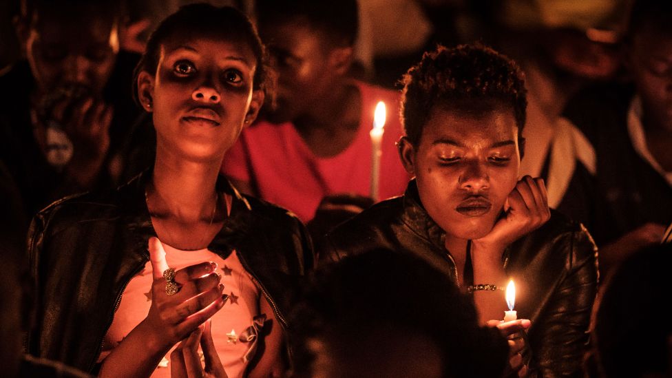 Женщины держат свечи во время ночного бдения и молитвы на стадионе «Амахоро» в рамках празднования 25-й годовщины геноцида 1994 года в Кигали, Руанда, 7 апреля 2019 г.
