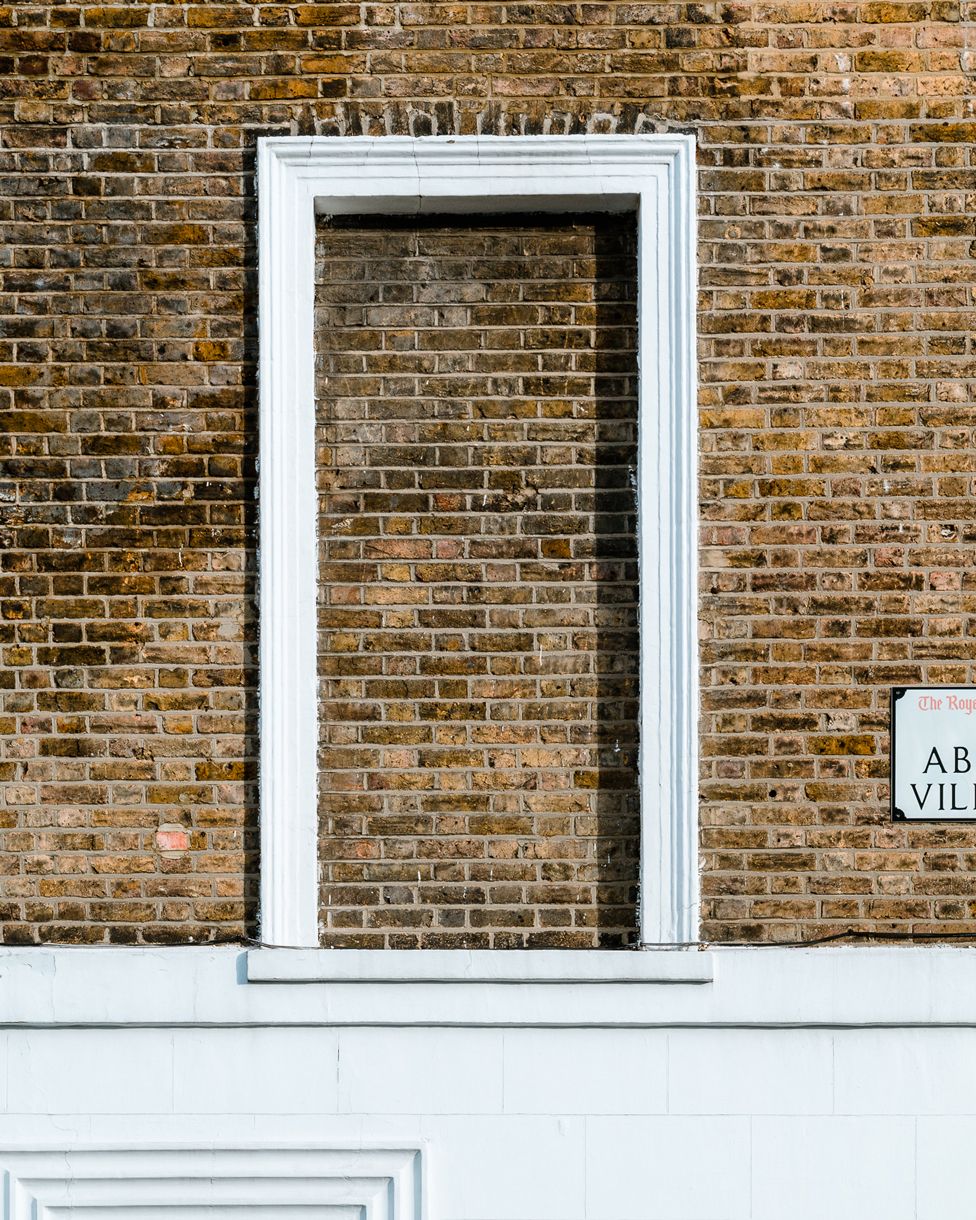 Brick wall with a single blocked window, on Abingdon Villas, London