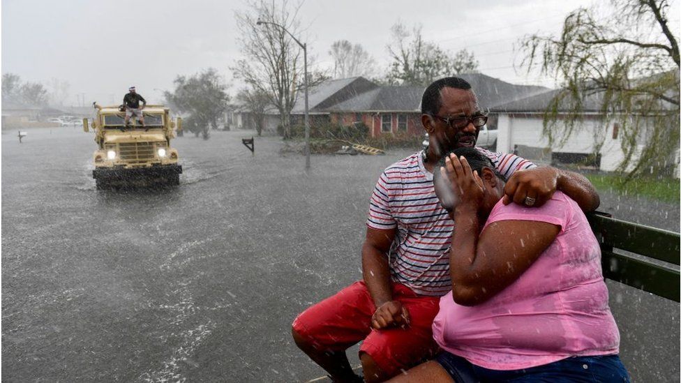 people evacuate from a flooded neighborhood in LaPlace, Louisiana on 30 August, 2021
