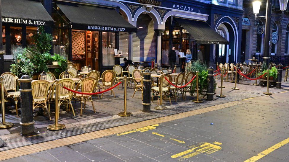 Empty tables and chairs outside bars on High Street in Cardiff