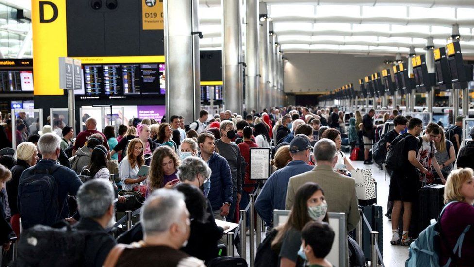 Passengers queue inside the departures terminal of Terminal 2 at Heathrow Airport. Photo taken June 27, 2022