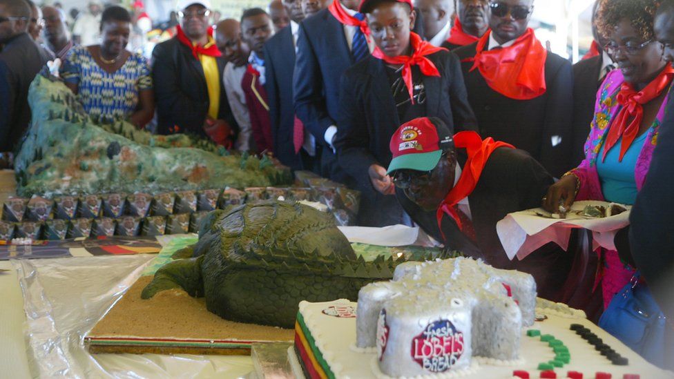 Zimbabwe's President Robert Mugabe blows candles on a crocodile shaped cake during a rally marking his 88th birthday in Mutare on February 25, 2012.