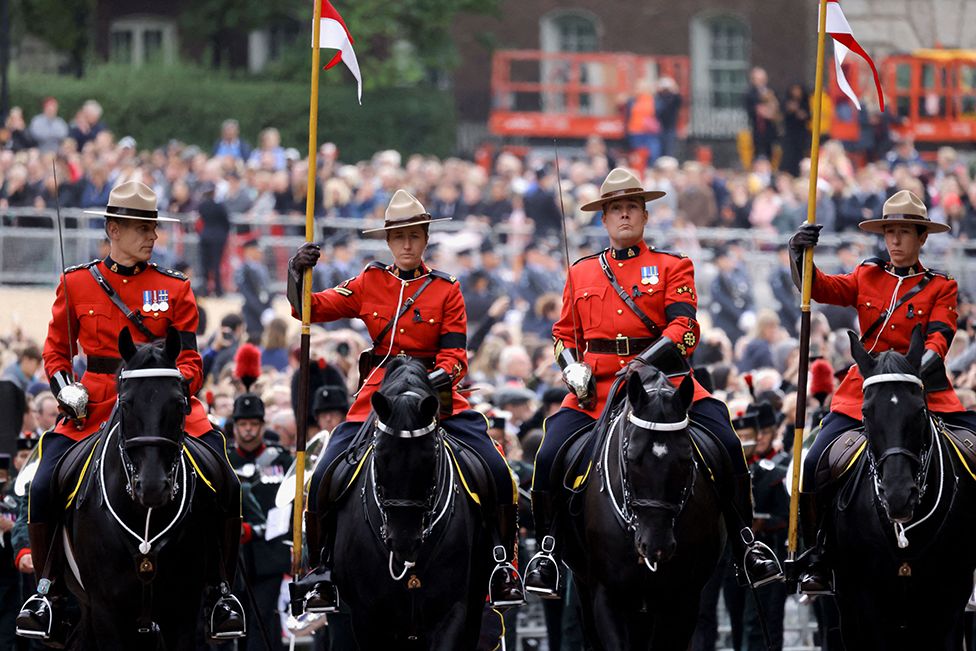 Члены Королевской канадской конной полиции принимают участие в шествии за гробом королевы Елизаветы II 19 сентября 2022 г., чтобы совершить последний путь в Виндзорский замок после государственной похоронной службы королевы Великобритании Елизаветы II