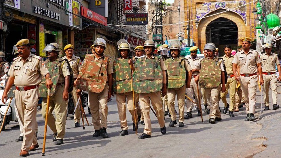 Policemen carry out a flag march through a street in Ajmer on June 29, 2022, following the alleged murder of a Hindu tailor by two Muslim men in Udaipur. - Western India's Udaipur city was placed under partial curfew to guard against potential sectarian violence after a video purporting to show the attempted beheading went viral