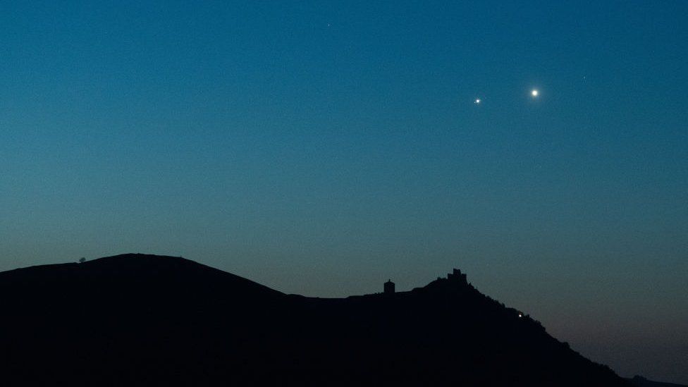 Planets Jupiter and Venus in conjunction rise before sunrise behind Rocca Calascio castle, Italy, on April 30, 2022.