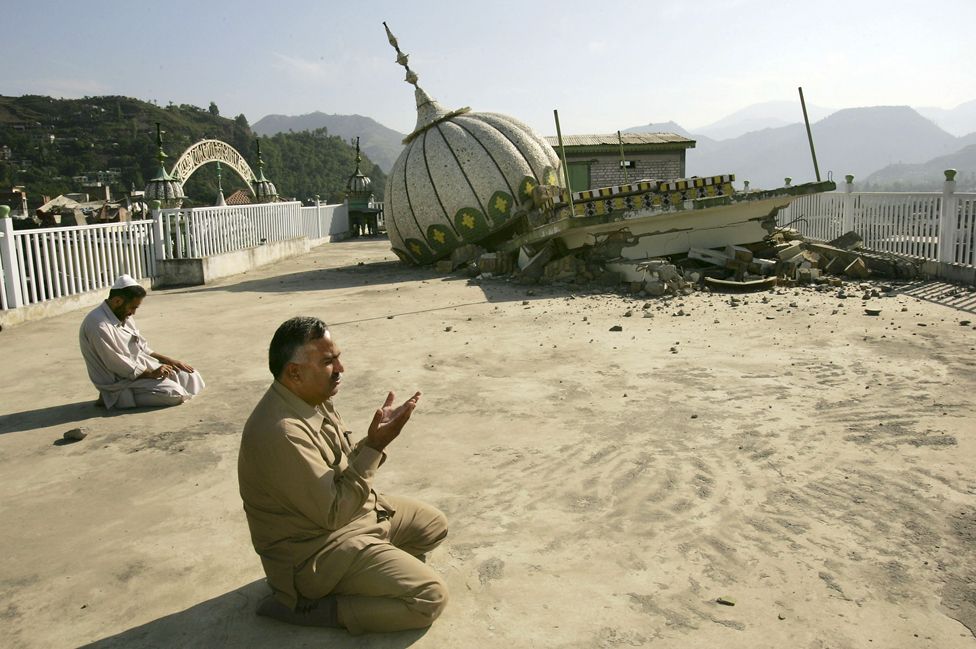 Мужчины молятся во время пятничной молитвы 28 октября 2005 года в мечети Джама Хаман Вали, разрушенной землетрясением в Музаффарабаде.