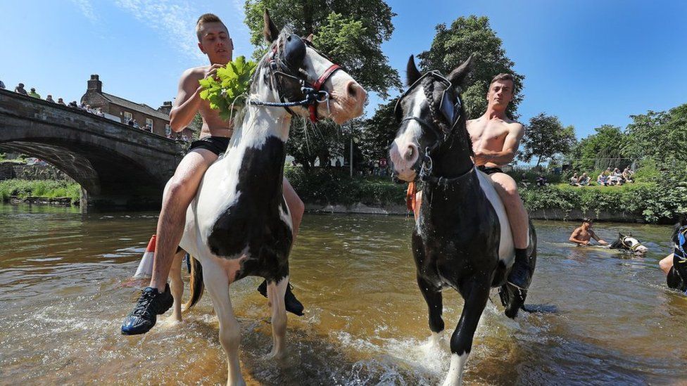People riding horses in the river Eden