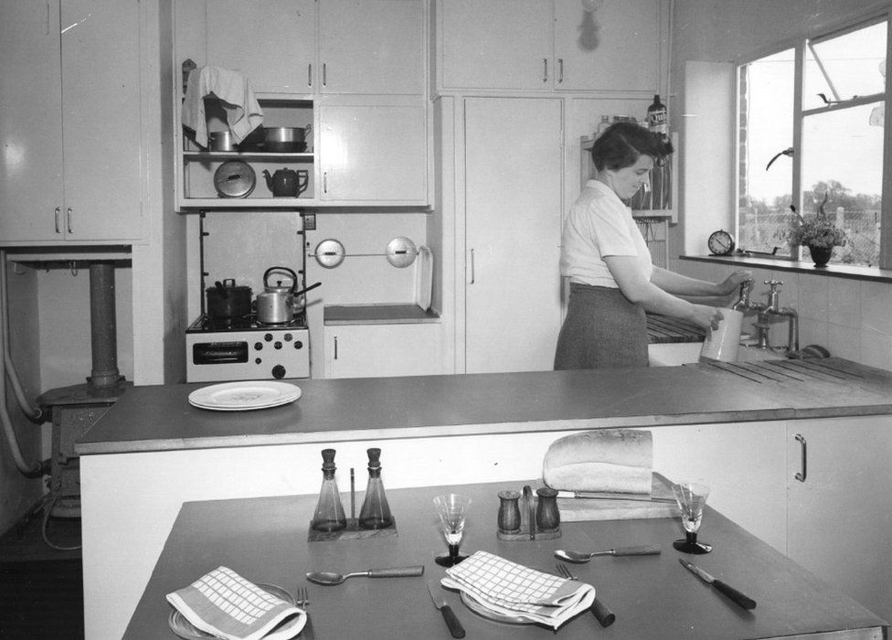 A housewife fills a jug in the kitchen diner of a brand new three-bedroom terraced house in Harlow New Town