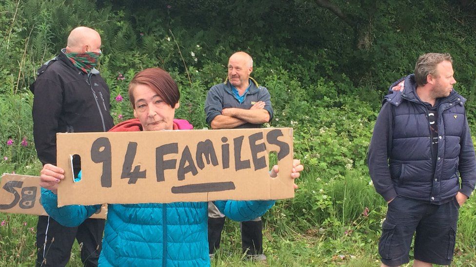 Protestor at Northwood tissue factory in Penygroes, Gwynedd, hold sign stating: "94 families"