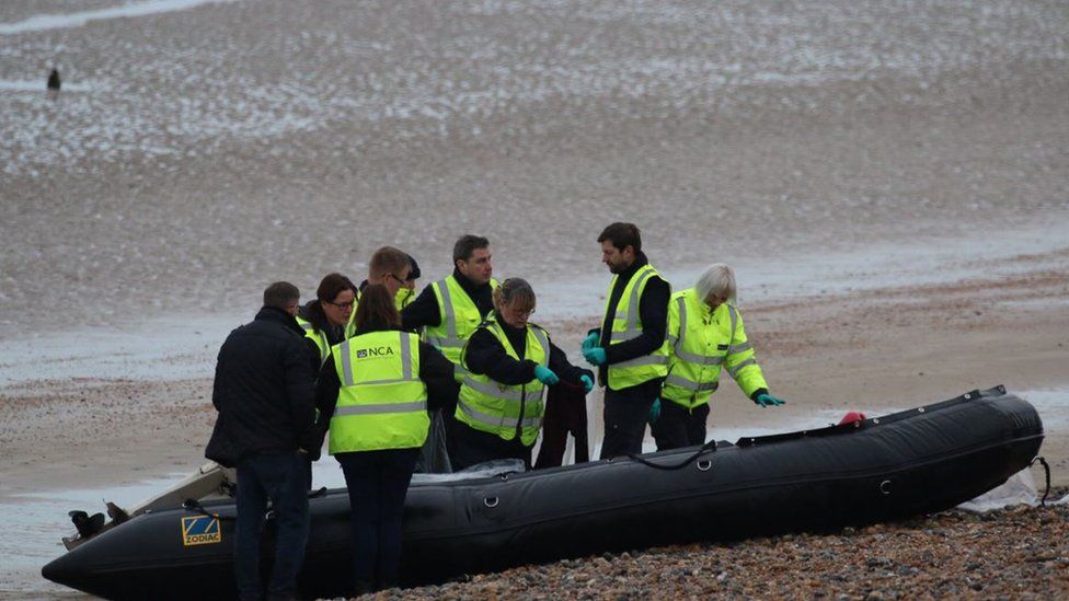 National Crime Agency officers examine a boat at Greatstone beach in Kent that arrived carrying 12 migrants on 31 December 2018