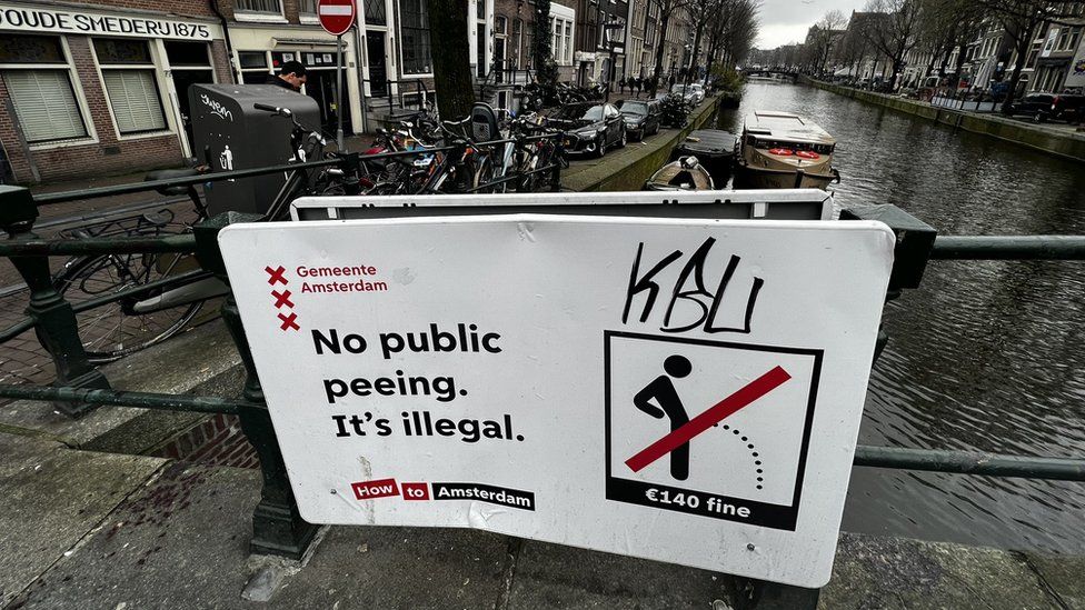 Image shows a sign warning against public urination