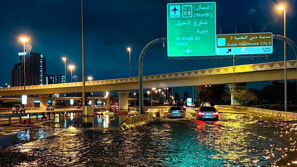 Cars drive through floodwater in Dubai early on 17 April 2024