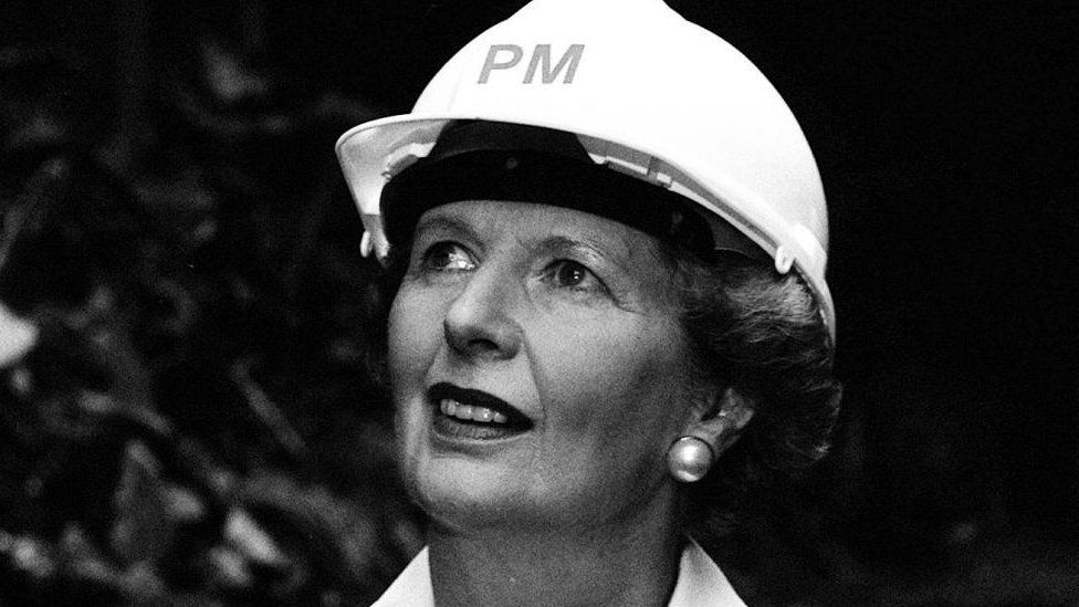 Margaret Thatcher wearing hard hat bearing the initials 'PM'