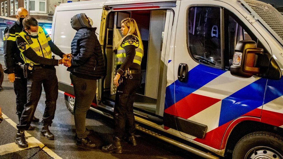 Police arrest a person during the curfew in Rotterdam South, the Netherlands, 27 January 2021
