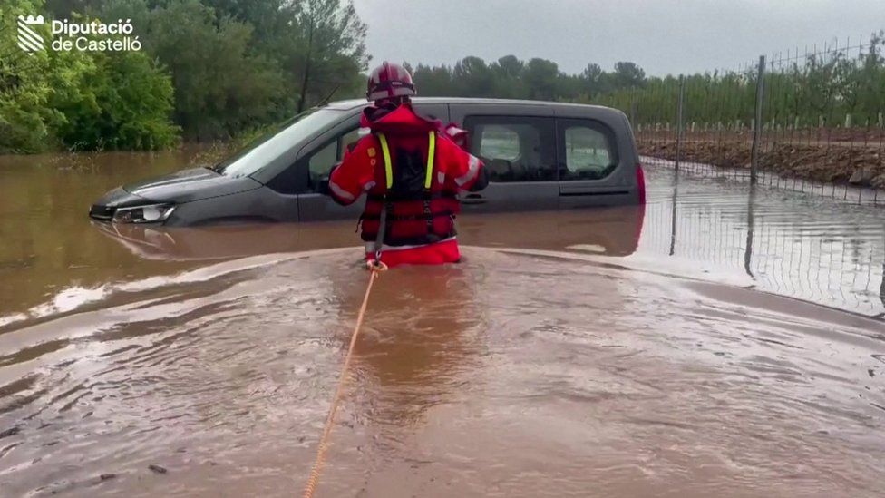 Firefighters help man leave vehicle trapped in floodwaters in Spain's Castelló province.