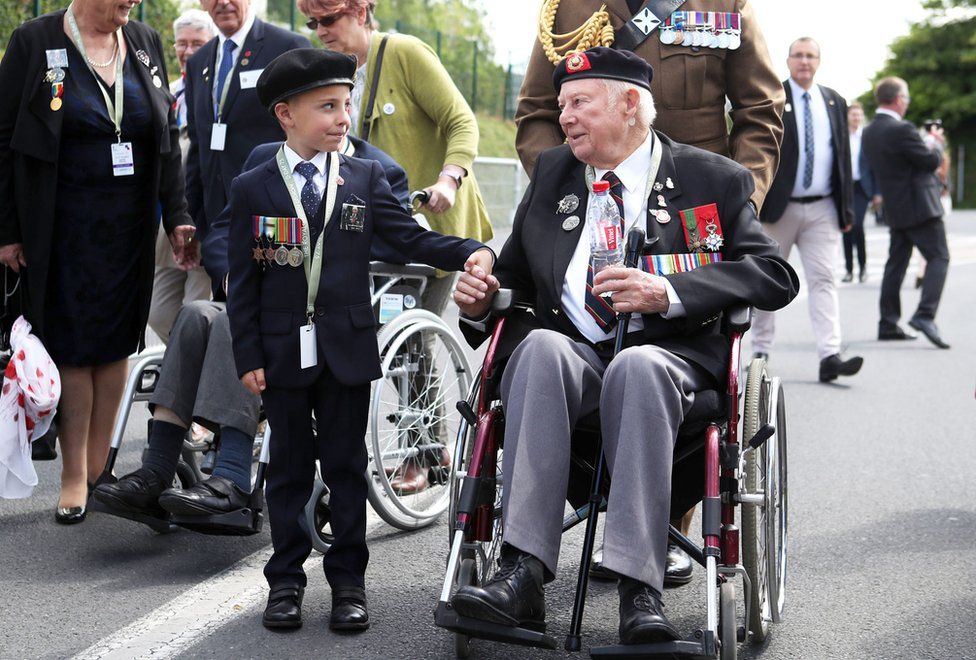 D-Day veteran John Quinn holds hands with George Sayer