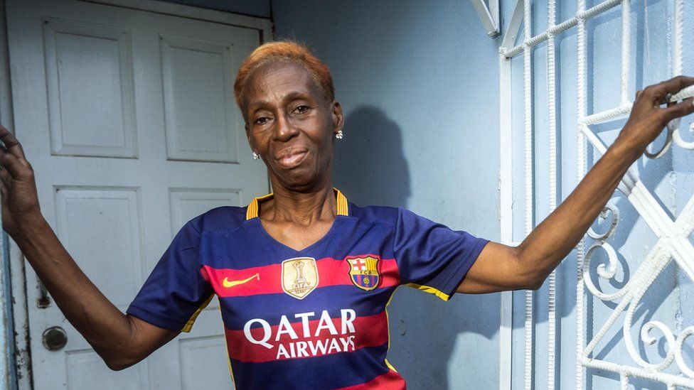 Pauline Perez poses for a picture at the entrance to her home