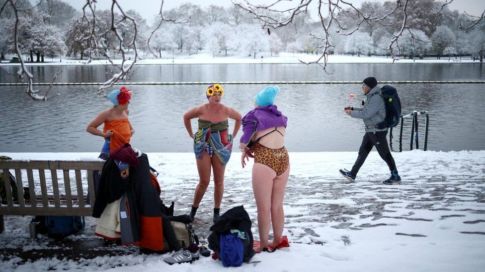 Swimmers dry themselves up after taking a dip in Serpentine lake, as cold weather continues