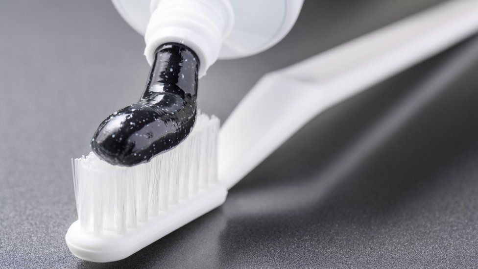 Toothpaste containing charcoal on a toothbrush