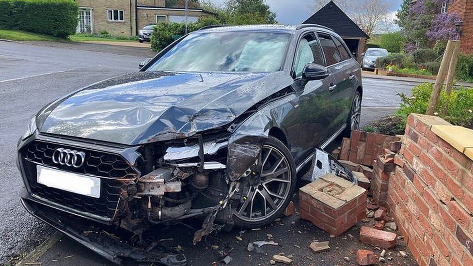 Car damaged along with a wall following crash