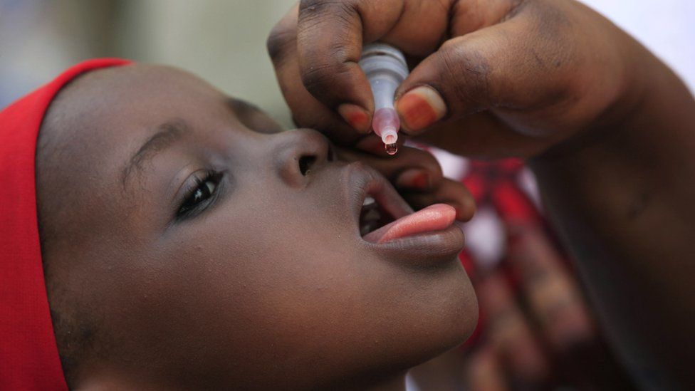 In this Sunday, April 13, 2014 file photo, an unidentified health official administers a polio vaccine to a child in Kawo Kano, Nigeria.