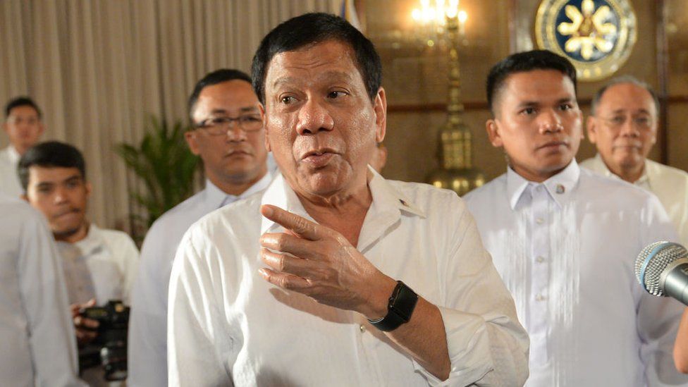 Philippine President Rodrigo Duterte (C) gestures as he talks to members of the media