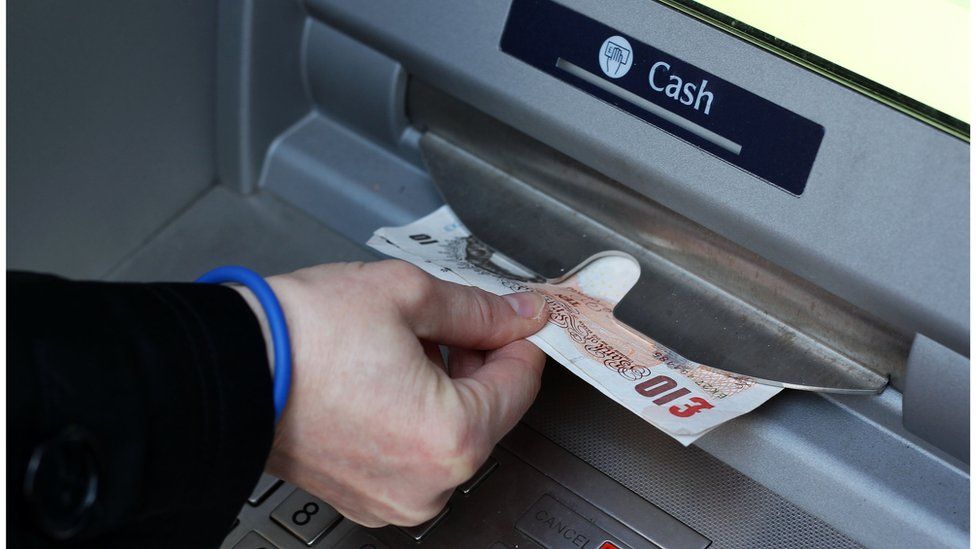 Close up photo of British money being taken out of an ATM, on 18 March 2013.