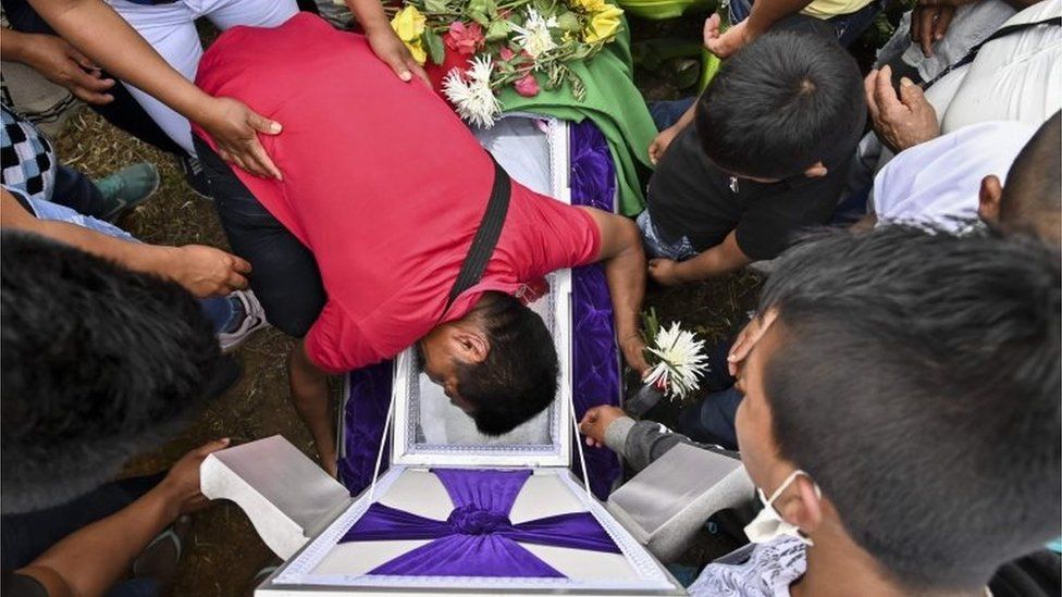A relative mourns over the coffin of Kevin Mestizo, who was killed in an attack on Saturday