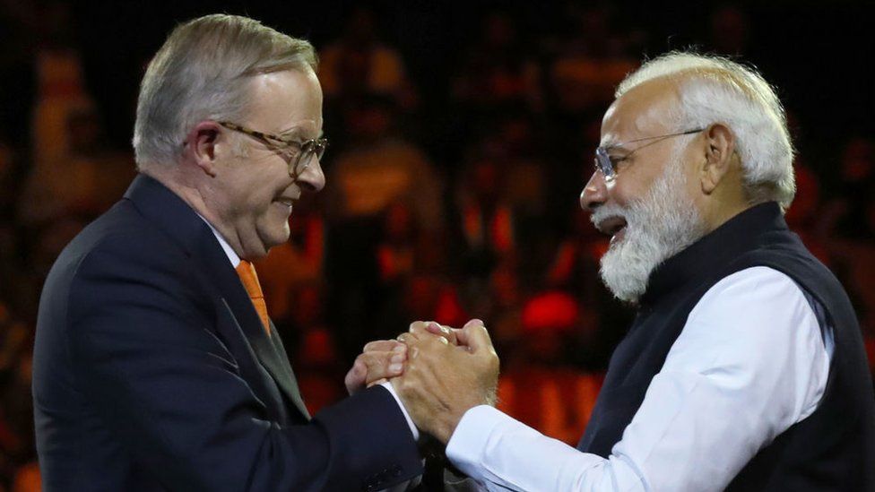 : India's Prime Minister Narendra Modi (R) and Australia's Prime Minister Anthony Albanese shake hands while attending an Indian cultural event on May 23, 2023 at the Qudos Bank Arena in Sydney, Australia.