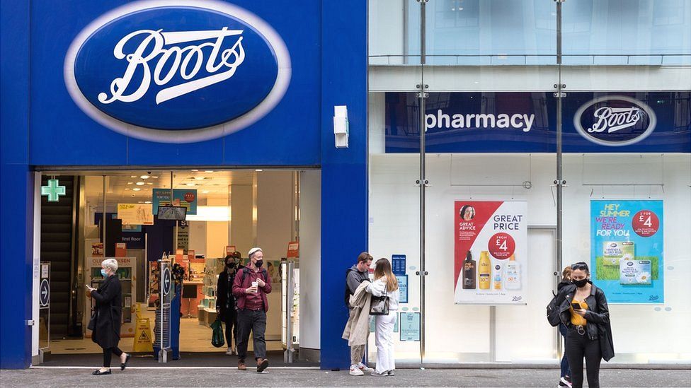 Shoppers pass by a Boots pharmacy in London.