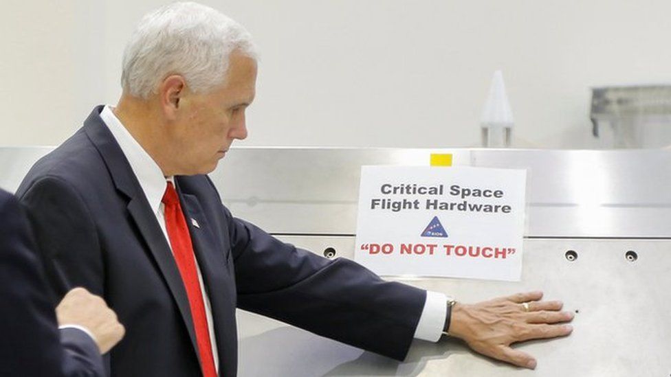 US Vice-President Mike Pence touches a piece of hardware with a warning label "Do Not Touch" at the Kennedy Space Center, 6 July 2017