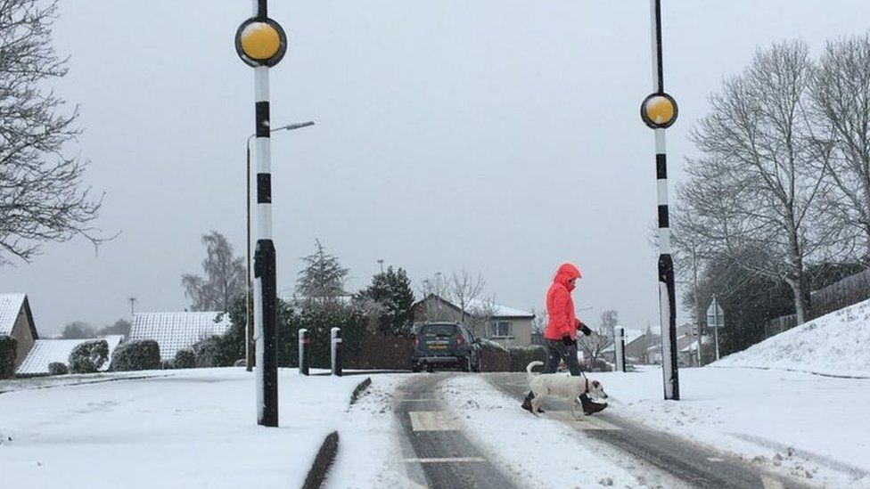 Person crossing snow-covered road