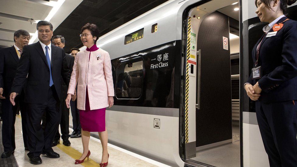 Ma Xingrui, governor of Guangdong Province, front row left, and Carrie Lam, Hong Kong's chief executive, centre, stand next to a Guangzhou-Shenzhen-Hong Kong Express Rail Link (XRL) train bound for Guangzhou Nan Station on a platform at West Kowloon Station in Hong Kong, China, 22 September 2018