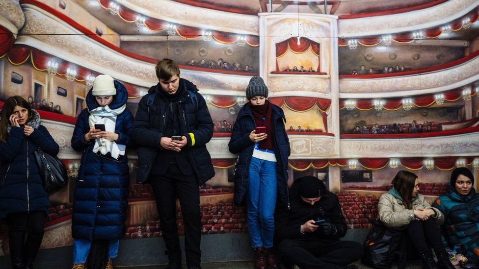 Civilians take shelter in a metro station during an airstrike alert in the centre of Kyiv on December 5, 2022