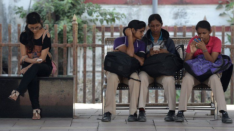 Indian women check their mobile phones at a free Wi-Fi zone in Mumbai in February 2016