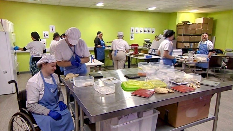 People working at large kitchen table