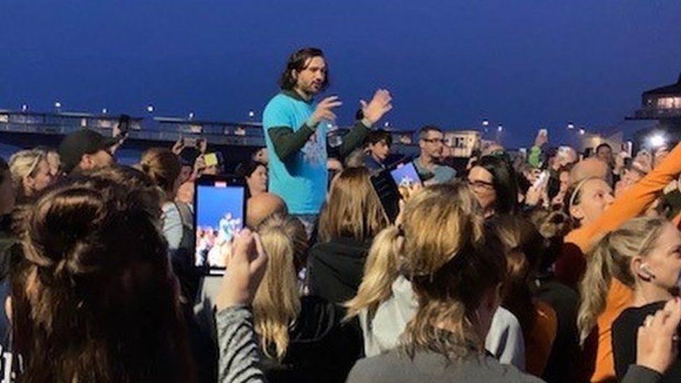 Joe Wicks talking to a crowd of people who are filming him on their phones