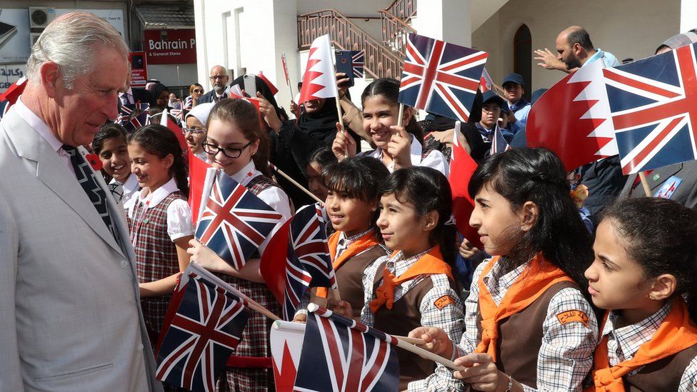 Prince Charles greets schoolchildren during a visit to Manama's Krishna Temple