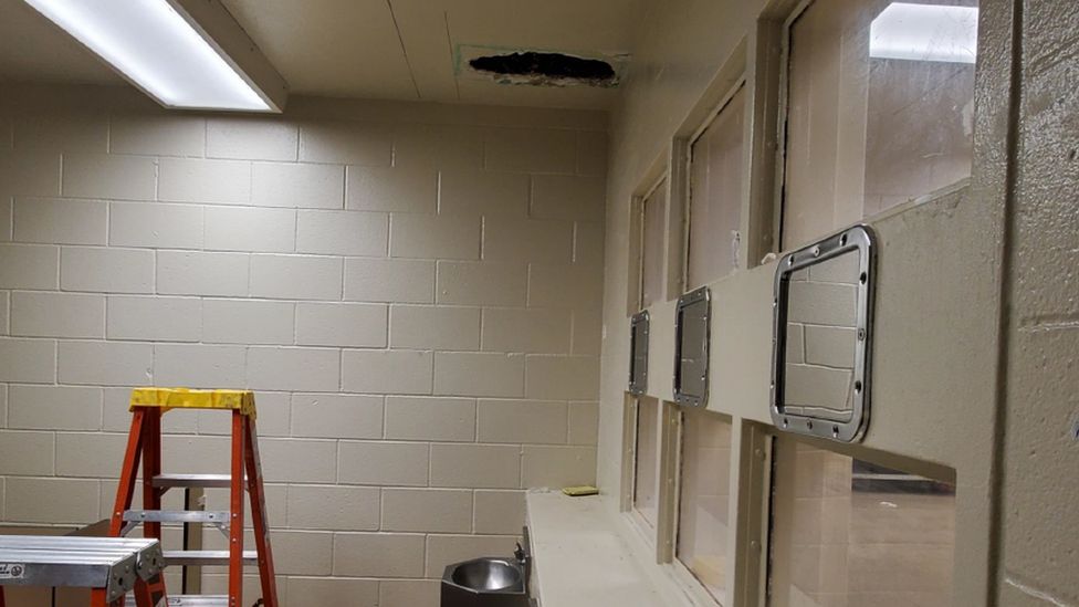 A picture showing a hole in the ceiling of a jail's toilet, where two suspects climbed through